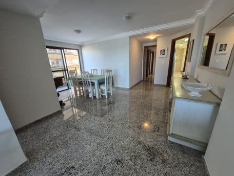Sala de jantar ampla com piso em granito, mesa com cadeiras e aparador com espelho.